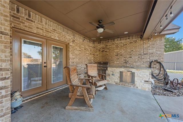 view of patio / terrace with exterior kitchen, french doors, a sink, a grill, and a ceiling fan