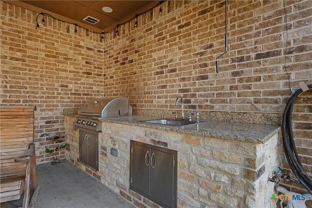 view of patio featuring an outdoor kitchen, visible vents, a sink, and a grill