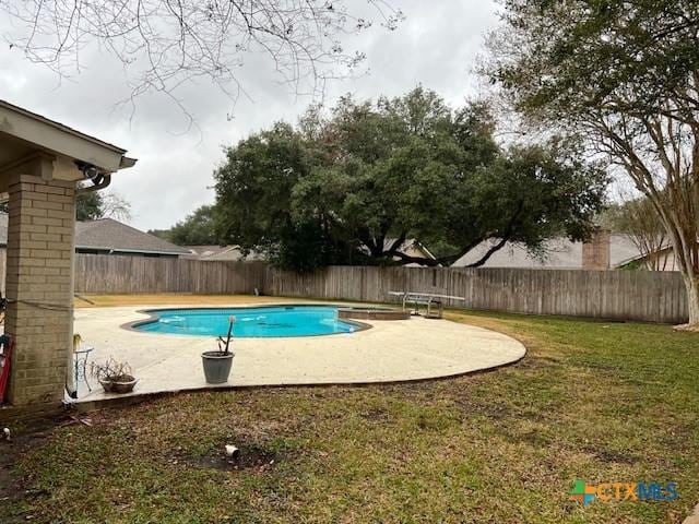 view of swimming pool with a patio, a diving board, and a yard