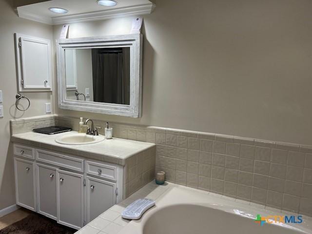 bathroom featuring vanity, a washtub, and ornamental molding