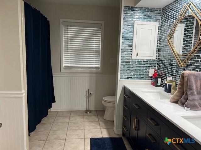 bathroom featuring tile patterned flooring, vanity, and toilet