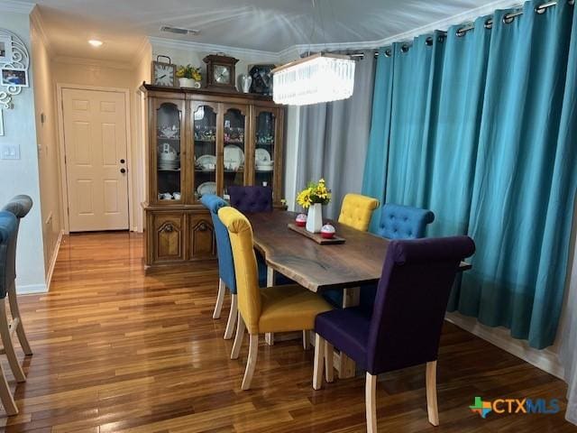 dining room featuring hardwood / wood-style floors and crown molding