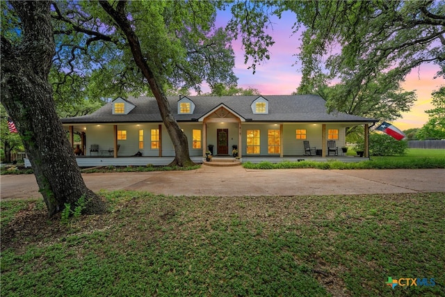 view of front of home with covered porch and a lawn