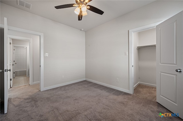 unfurnished bedroom featuring visible vents, baseboards, a walk in closet, and carpet flooring