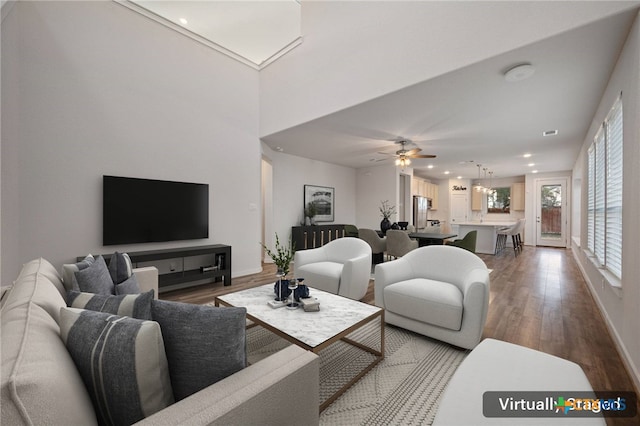 living area featuring ceiling fan, baseboards, wood finished floors, and recessed lighting