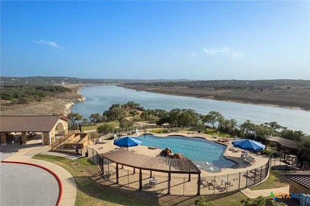 pool featuring a gazebo, a patio area, a water view, and fence