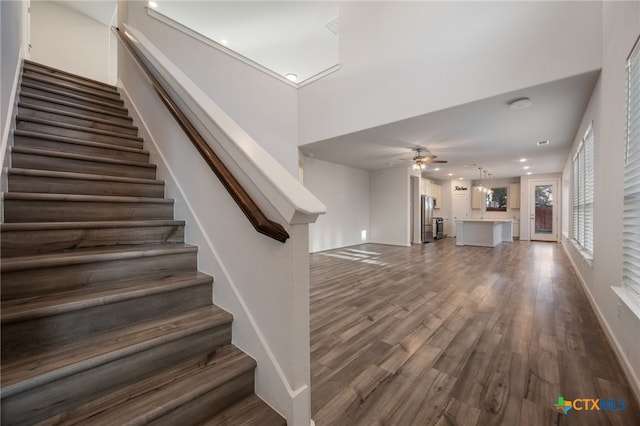 stairway with recessed lighting, baseboards, ceiling fan, and wood finished floors