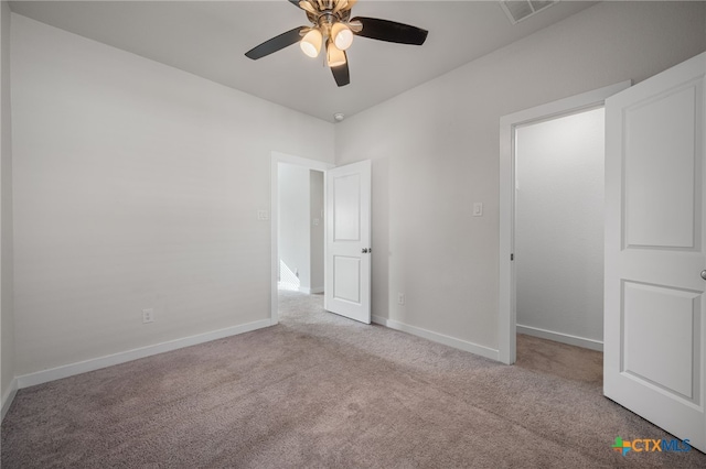 empty room with visible vents, baseboards, a ceiling fan, and carpet floors