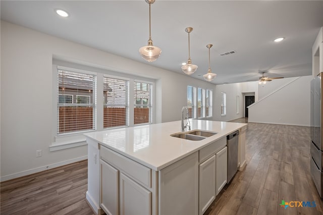 kitchen with stainless steel dishwasher, dark wood-type flooring, visible vents, and a sink