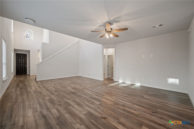 unfurnished living room with a ceiling fan, visible vents, dark wood-style flooring, and baseboards