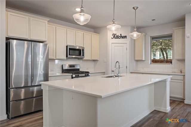 kitchen featuring a sink, stainless steel appliances, dark wood-style floors, and light countertops