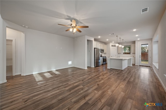 kitchen with visible vents, open floor plan, stainless steel appliances, light countertops, and dark wood-style flooring