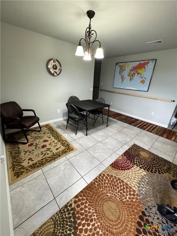 interior space with light tile patterned floors and a chandelier