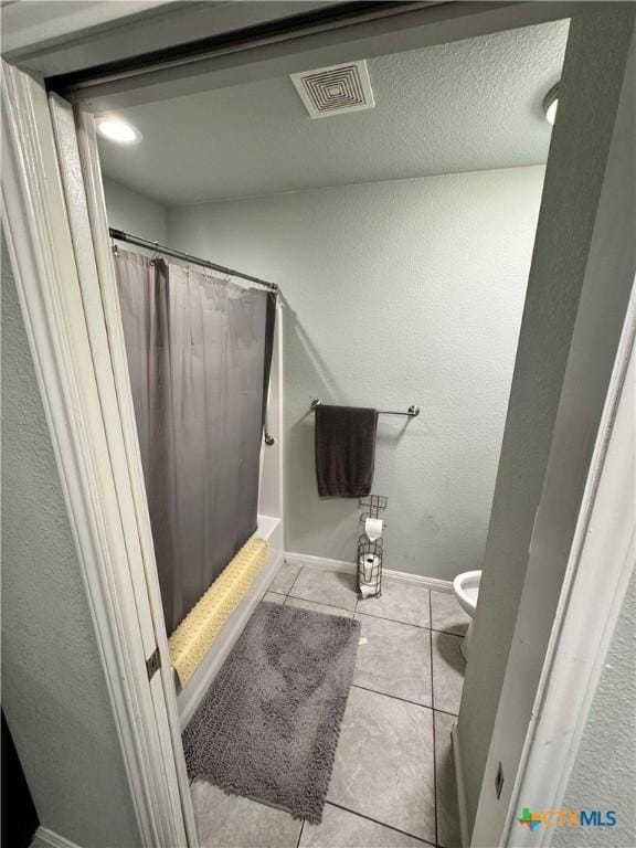 bathroom with tile patterned floors, a shower with curtain, and toilet