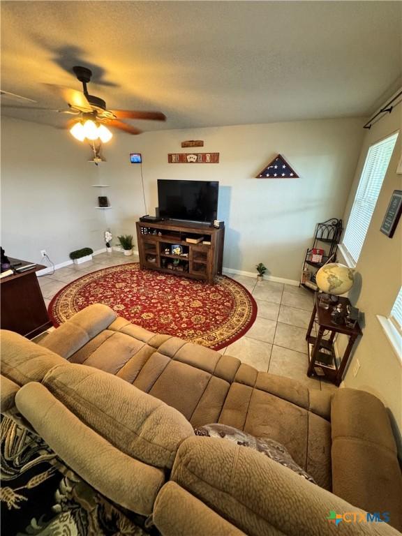 tiled living room featuring ceiling fan