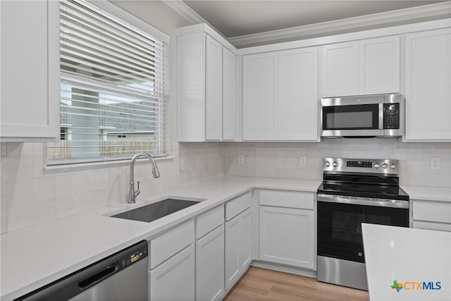704 Seven Springs Dr, Temple, TX 76502 - kitchen with tasteful backsplash, a sink, light countertops, white cabinetry, and stainless steel appliances