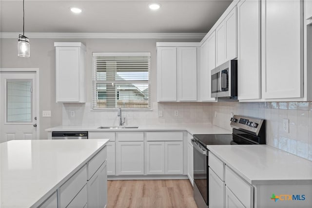 704 Seven Springs Dr, Temple, TX 76502 - kitchen featuring stainless steel appliances, white cabinetry, a sink, and ornamental molding