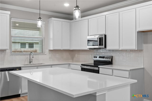 704 Seven Springs Dr, Temple, TX 76502 - kitchen with light countertops, crown molding, white cabinets, appliances with stainless steel finishes, and a sink