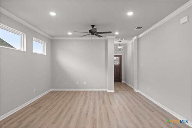 spare room featuring ornamental molding, wood finished floors, a ceiling fan, and baseboards