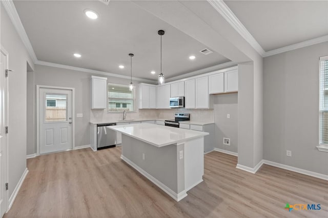 704 Seven Springs Dr, Temple, TX 76502 - kitchen featuring light wood-type flooring, ornamental molding, white cabinetry, appliances with stainless steel finishes, and a sink