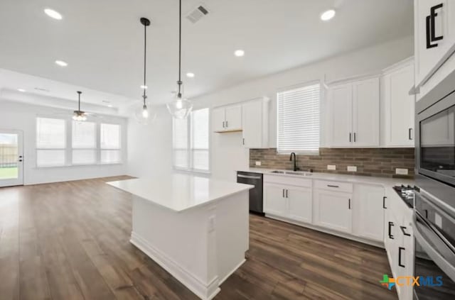 kitchen with white cabinets, stainless steel appliances, and decorative light fixtures