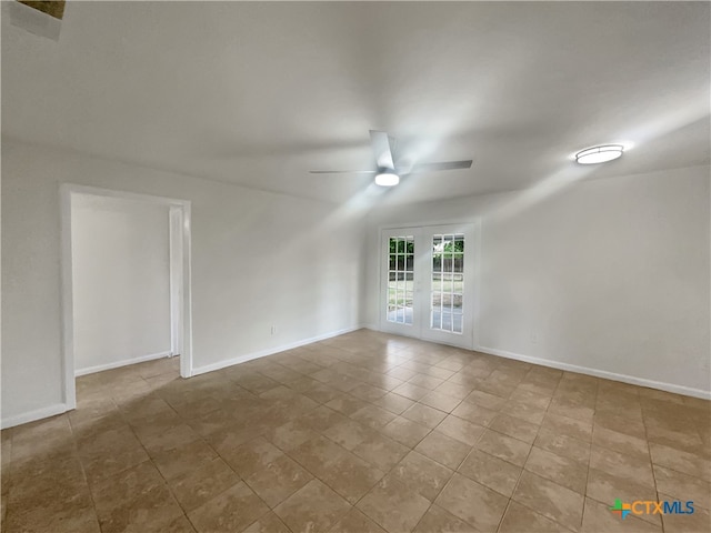 tiled spare room featuring french doors and ceiling fan