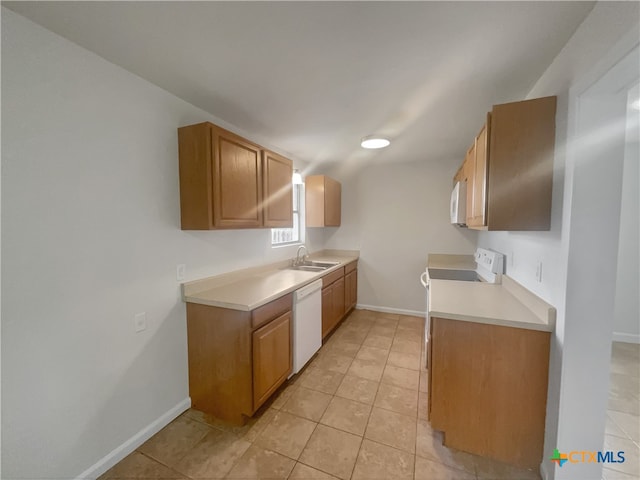 kitchen featuring white appliances, sink, and light tile patterned flooring