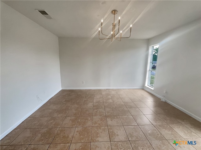 unfurnished room with a chandelier