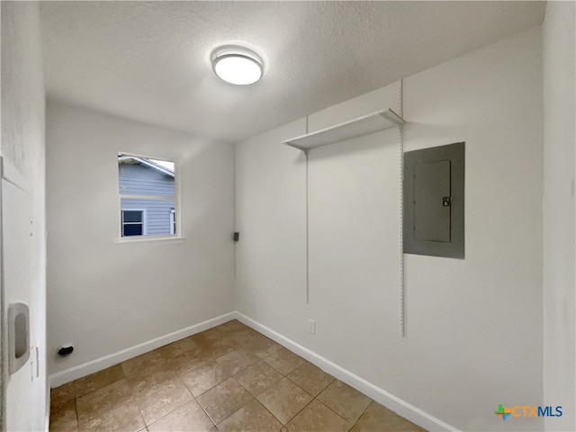 laundry area with electric panel and a textured ceiling