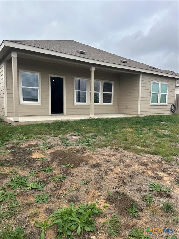 rear view of house with a patio area and a lawn