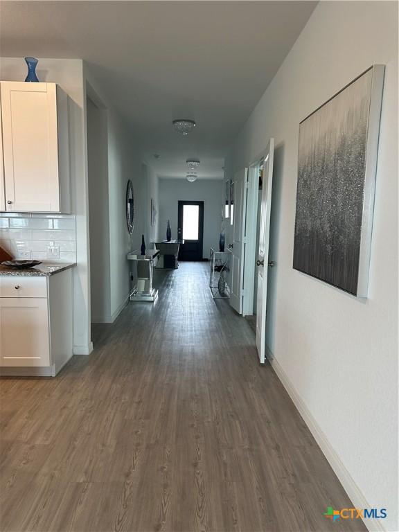 corridor with dark hardwood / wood-style flooring