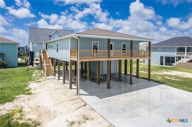 rear view of property featuring a lawn and a carport