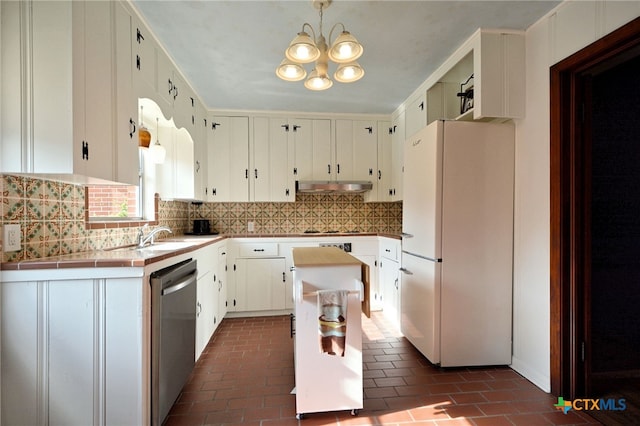 929 E Cedar St, Seguin, TX 78155 - kitchen featuring freestanding refrigerator, stainless steel dishwasher, backsplash, and under cabinet range hood