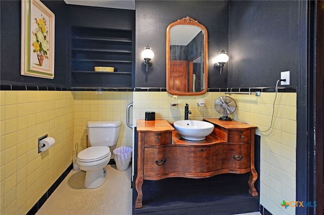 929 E Cedar St, Seguin, TX 78155 - bathroom with tile walls, vanity, and a wainscoted wall
