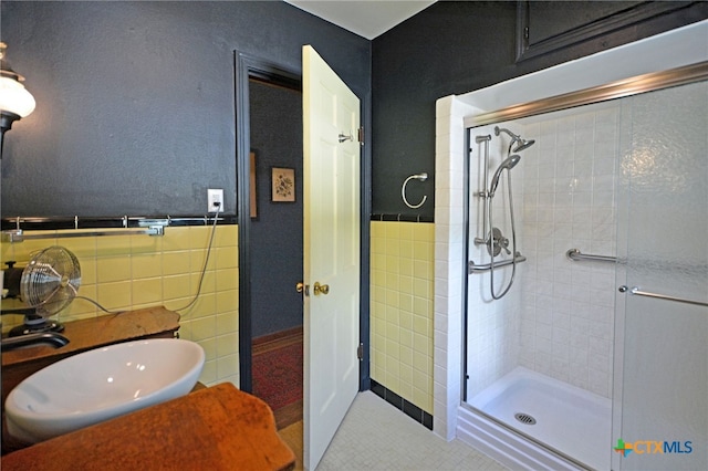 929 E Cedar St, Seguin, TX 78155 - bathroom with a stall shower, tile walls, tile patterned floors, and a wainscoted wall