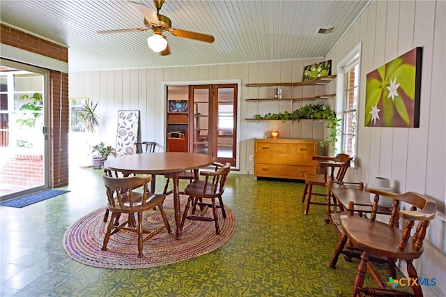 929 E Cedar St, Seguin, TX 78155 - dining area with wood walls, tile patterned floors, and a ceiling fan