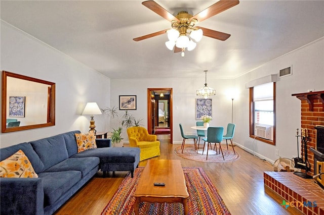 929 E Cedar St, Seguin, TX 78155 - living room with wood finished floors, a ceiling fan, cooling unit, and a fireplace
