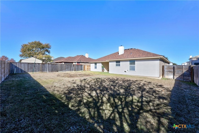 rear view of property with a lawn