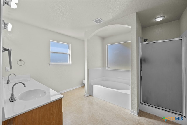 full bathroom with plus walk in shower, vanity, a textured ceiling, and toilet