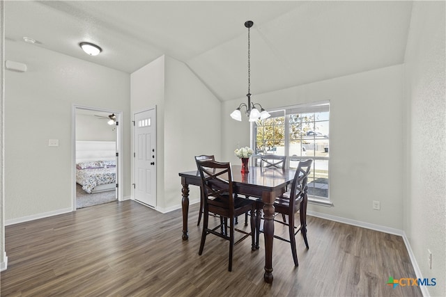 dining space featuring vaulted ceiling, ceiling fan with notable chandelier, and dark hardwood / wood-style floors