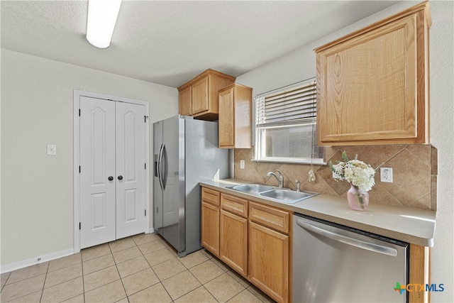 kitchen featuring sink, decorative backsplash, light tile patterned floors, a textured ceiling, and stainless steel appliances