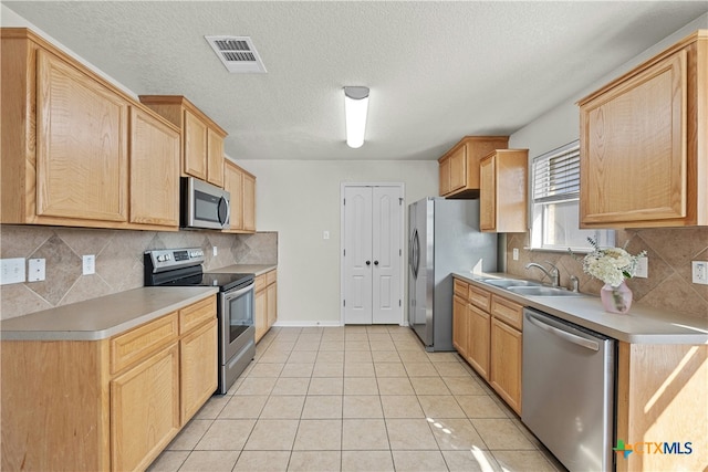 kitchen with backsplash, sink, light brown cabinetry, light tile patterned flooring, and stainless steel appliances