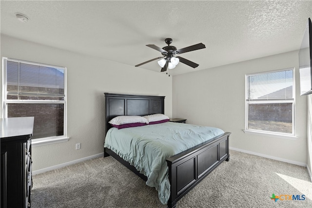 bedroom with carpet flooring, ceiling fan, and a textured ceiling