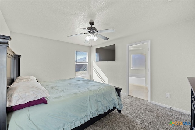 carpeted bedroom with ensuite bath, ceiling fan, and a textured ceiling