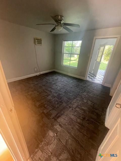 spare room with ceiling fan, baseboards, and plenty of natural light