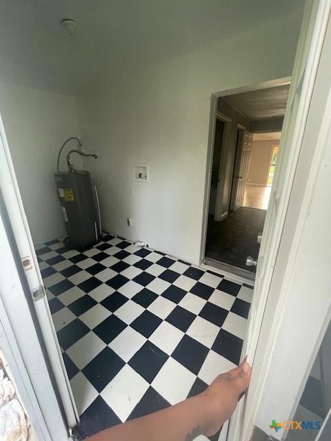 clothes washing area featuring light floors, electric water heater, hookup for a washing machine, and laundry area