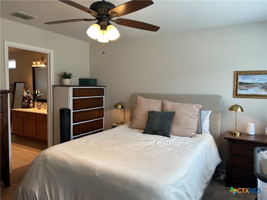 21934 Ruby Run, San Antonio, TX 78259 - bedroom with connected bathroom, ceiling fan, and a textured ceiling