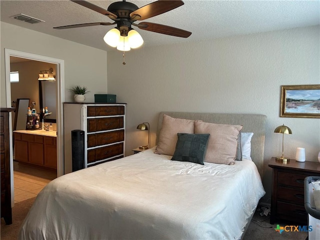 21934 Ruby Run, San Antonio, TX 78259 - bedroom with connected bathroom, ceiling fan, and a textured ceiling