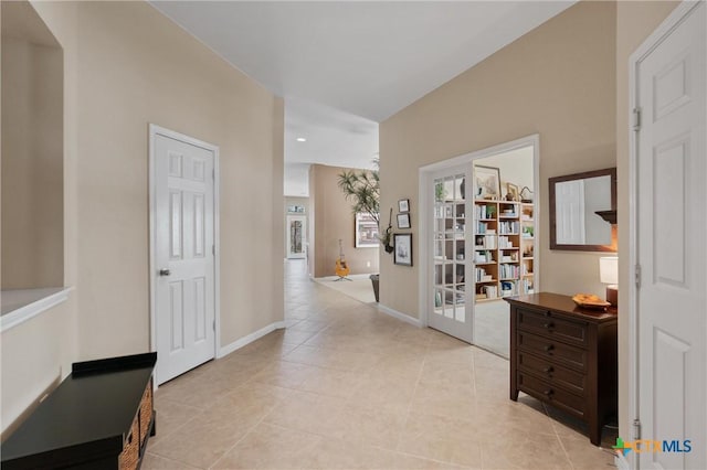 hallway featuring light tile patterned floors and baseboards