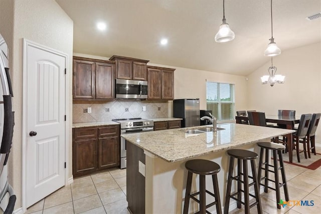 4004 Brookside Dr, Killeen, TX 76542 - kitchen with stainless steel appliances, backsplash, lofted ceiling, light tile patterned floors, and an island with sink